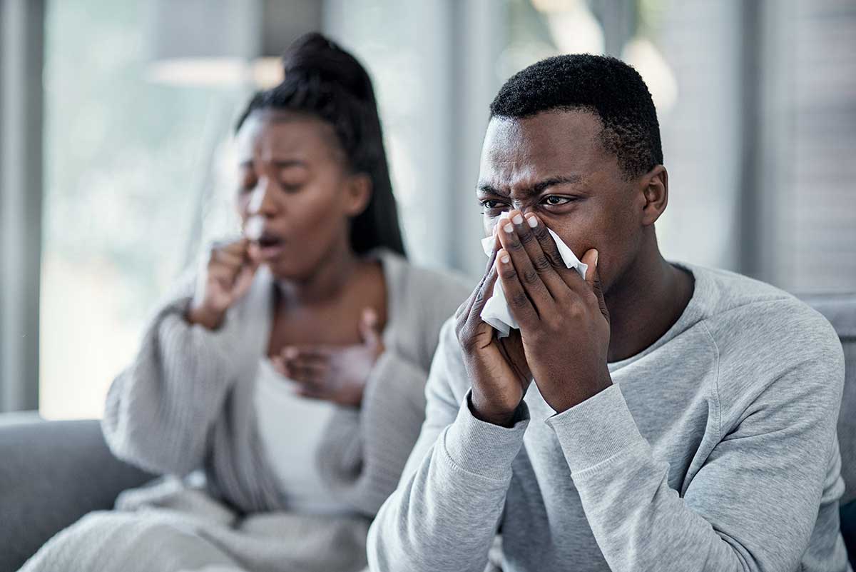 Man and woman sneezing and coughing